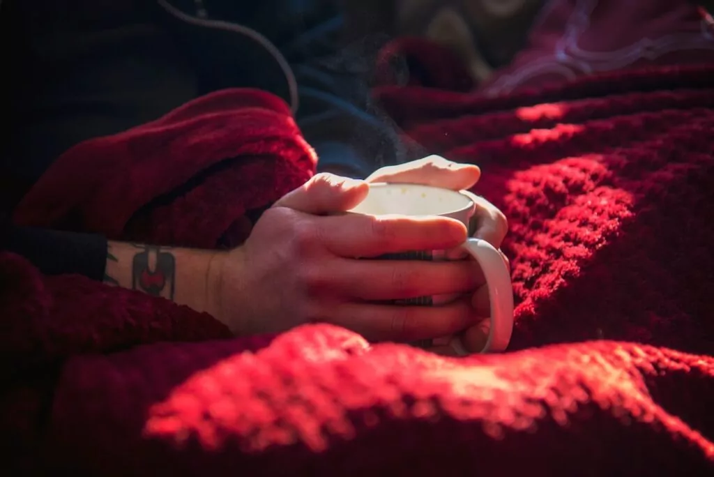 Person holding a warm cup of Chinese herbal tea